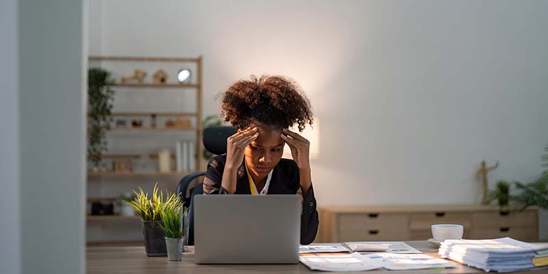Stress, anxiety and burnout with a business black woman at work using a laptop while suffering from a headache. Compliance, computer and mental health with a female employee struggling on a deadline
